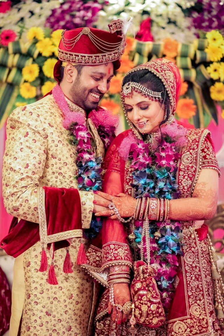 A joyful Indian couple wearing traditional wedding attire