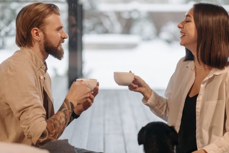 A couple smiling and talking over coffee